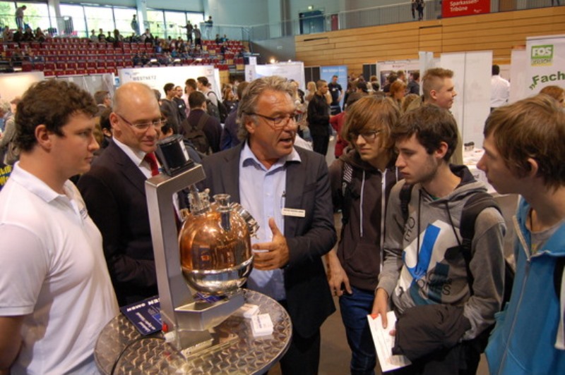 Chef Armin Vossen und Azubi Dominik Greuel im Gespräch mit drei jungen Männern auf Berufssuche. 1400 junge Leute nutzten die Ausbildungsbörse in der Arena Kreis Düren, um sich an den 75 Ständen über Berufe und Arbeitgeber zu informieren. 