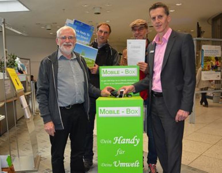 Walter Jordans (li.) und Reinhard Schultz-Hock (2.v.r.) vom BUND und Elmar Farber von der Evangelischen Kirchengemeinde (2.v.l.) haben mit Hans-Jörg Feltes vom Bürgerbüro der Stadt Düren im Verwaltungsgebäude am Markt eine Handy-Sammelbox aufgestellt.