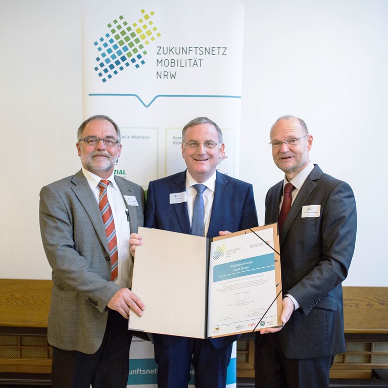 Foto: Michael von der Mühlen (re.), Staatssekretär im Verkehrsministerium NRW, überreichte Dürens Bürgermeister Paul Larue (mi.) und Tiefbauamtsleiter Heiner Wingels (li.) die Mitgliedsurkunde.