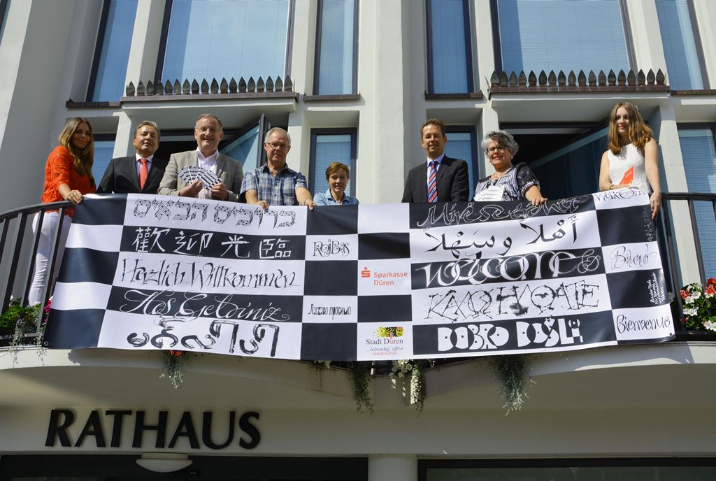 Ein Banner mit dem in viele Sprachen übersetzten Willkommensgruß stimmt auf das Stadtfest ein 