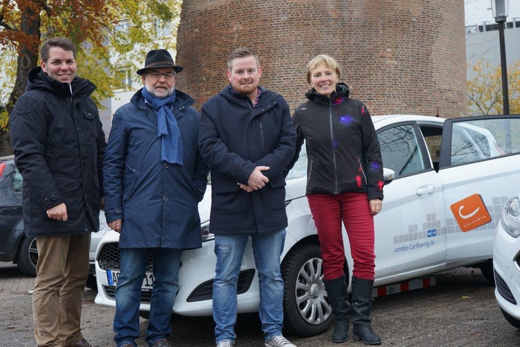 Präsentieren gemeinsam die neue cambio-Station am Pletzerturm: Dürens Erster Beigeordneter Thomas Hissel (links) mit Gisela Warmke, Geschäftsführerin von cambio (rechts) sowie Heiner Wingels (2.v.l.) und Benjamin Raßmanns von der Stadt Düren.