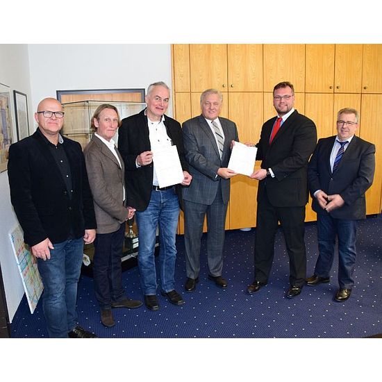 Landrat Wolfgang Spelthahn überreichte Bauherr Jens Emrich (2.v.r.) einen Förderbescheid des Landes NRW für den Quartierbau an der Schweizer Straße in Jülich. Einen weiteren Bescheid händigte er den Architekten Uwe Amend und Manfred Ott (2.u.3.v.l.) aus. Zudem im Bild: Alois Prinz (l.) und Hans-Jürgen Görgens (r.) vom Amt für Recht, Bauordnung und Wohnungswesen des Kreises Düren. 