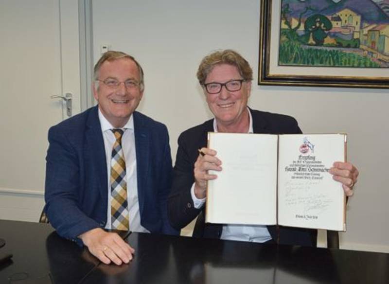 Foto: Bürgermeister Paul Larue (li.) und Harald „Toni“ Schumacher, beim Eintrag des ehemaligen Nationaltorhüters in das Goldene Buch der Stadt.