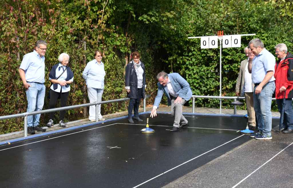 Foto: Unter fachmännischer Anleitung des SCAE-Vorsitzenden Michael Keßel (2.v.r.) nahm Bürgermeister Paul Larue mit einem ersten Wurf die neue Asphalt-stockschießbahn in Betrieb.  Foto: Stadt Düren.