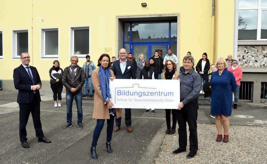 Sie haben den Übergang an der Schulstraße voll-zogen (von links): Bildungszentrumsleiter Heinz Lönneßen, Betriebsratsvorsitzender Dieter Tendyra, Geschäftsführerin Kathleen Büttner-Hoigt, Ge-schäftsführer Dr. Gereon Blum, Pflegedienstleiterin Anita Breinig, Michael Omsels und Gabriele Jendrzey von der low-tec sowie (im Hintergrund) die Schüler des neuen Ausbildungskurses.    Foto: Krankenhaus Düren 