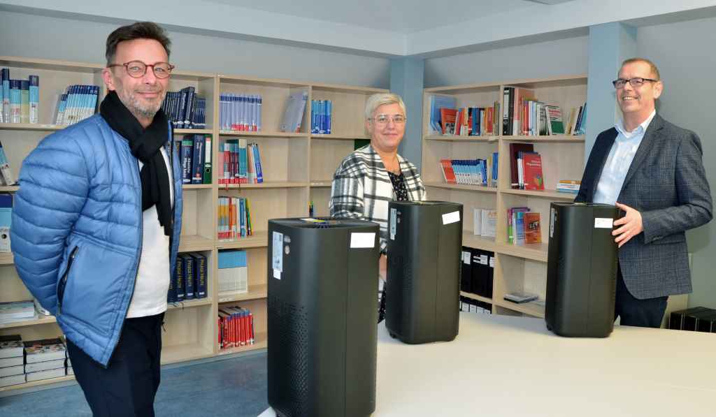 André Nowack und Maria Amparo Fernandez vom Pflegedienst Auxilio überbrachten Schulleiter Heinz Lönneßen Luftfiltergeräte für alle Klassenräume des Bildungszentrums.  Foto: Krankenhaus Düren / 