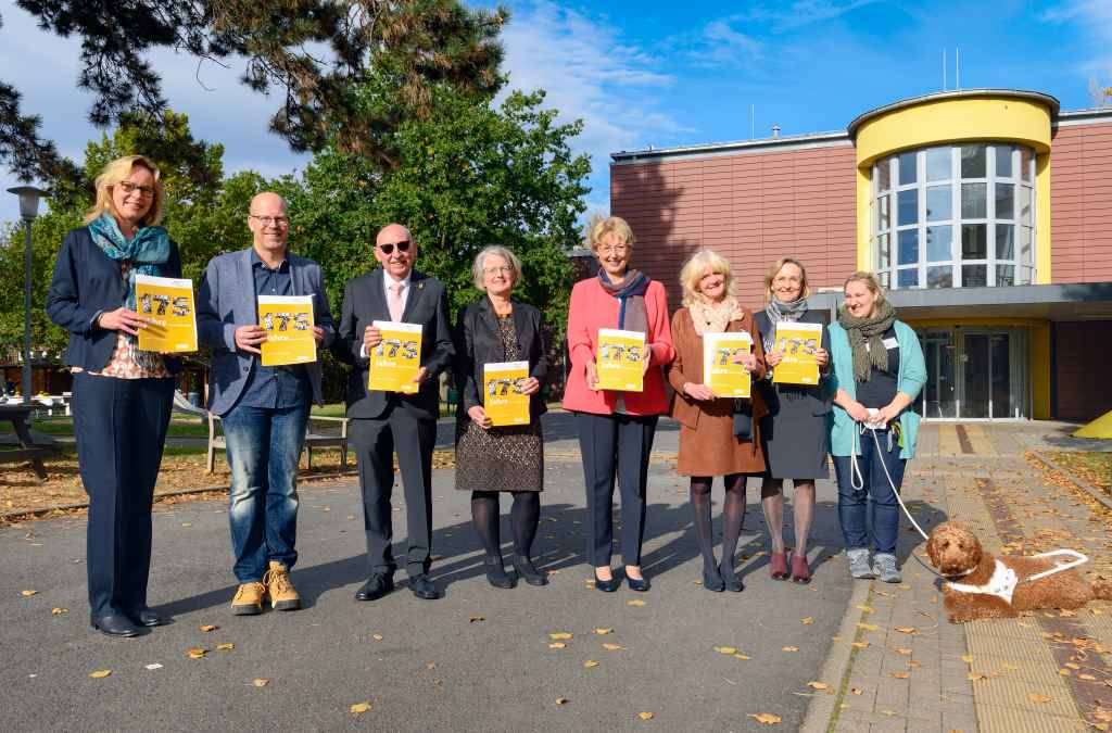 Beim Festakt zu 175+1 Jahren LVR-Louis-Braille-Schule in Düren (v.l.): Dr. Alexandra Schwarz (LVR), Wolfgang Schmitdt (Förderverein LVR-Louis-Braille-Schule), Rolf Peter Hohn (Stellv. Bürgermeister d. Stadt Düren), Sybille Haußmann (Dezernentin für Arbeit, Bildung und Integration des Kreises Düren), Karin Schmitt-Promny M.A. (Stellv. Vorsitzende d. Landschaftsversammlung Rheinland), Kerstin Grün-Klingebiel (Schulleiterin), Prof. Dr. Angela Faber (LVR), Nele Luffy-Hagen (Schul-Therapeutin) mit Blindenführhund Bolek.