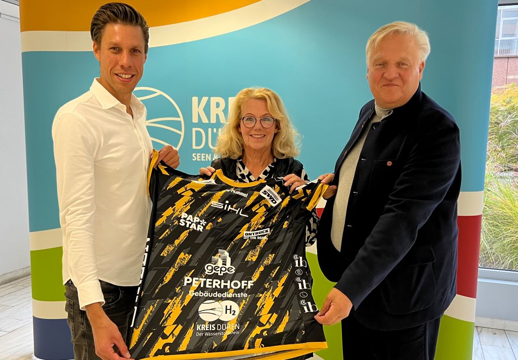 Powervolleys-Geschäftsführer Tomas Kocian-Falkenbach bei der Vorstellung des neuen Trikots mit Kreis-Düren-Logo. Annegret Greven (Kreis Düren) und Landrat Wolfgang Spelthahn (v.l.) sind begeistert. Foto: Kreis Düren