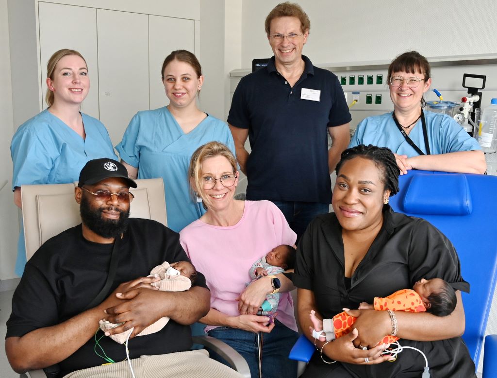 Foto (© T. Opgenorth):  Hinten v.l.: Denise Siebert Gesundheits- und Kinderkrankenpflegerin, Chantal Heinrich (Pflegefachkraft), Oberarzt Ulrich Bergsch, Oberärztin Magdalene Wiesner Vorne v.l.: Bob Mombele, Kerstin Schein-Adels (Bereichsleitung), Meola Djimbi und die Drillinge Asaël, Maël und Sanaïa