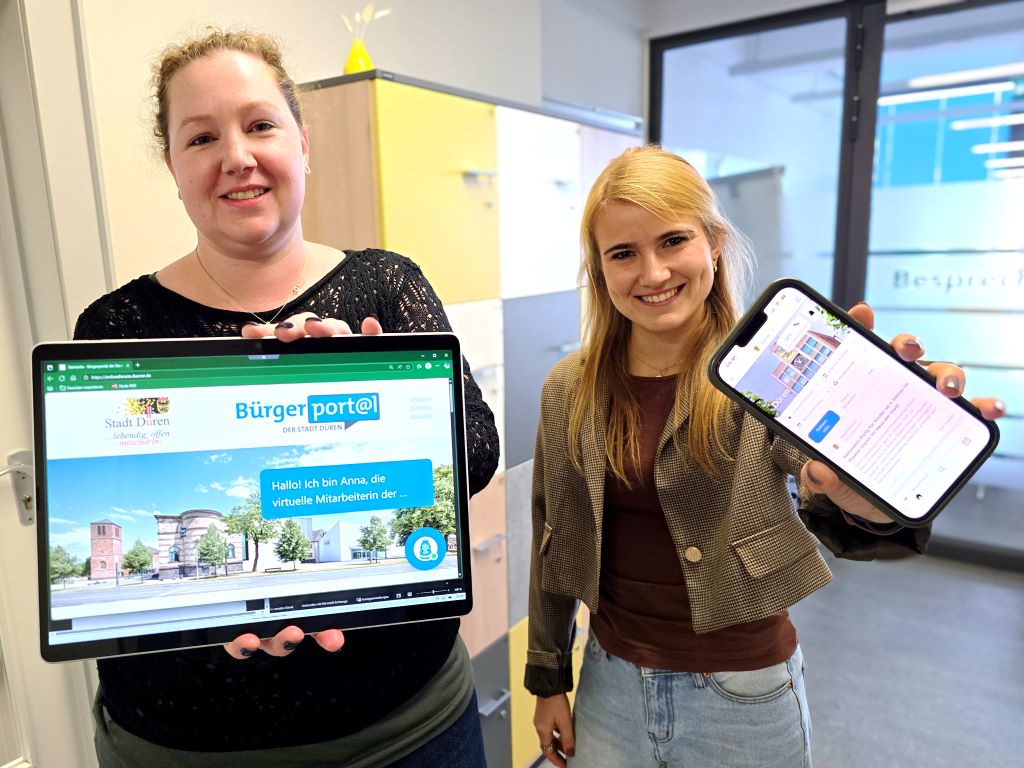 Sonja Erdmann (l.) und Sarah Porschen von der Abteilung „Organisation und IT“ im Hauptamt der Stadt Düren präsentieren die KI-gestützte Assistentin „Anna“ und die Heimat-Info-App für die Stadt Düren.